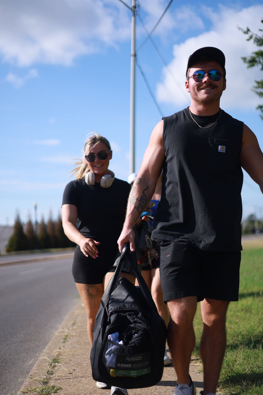 Two people outdoors with a clear sky and power line in the background
